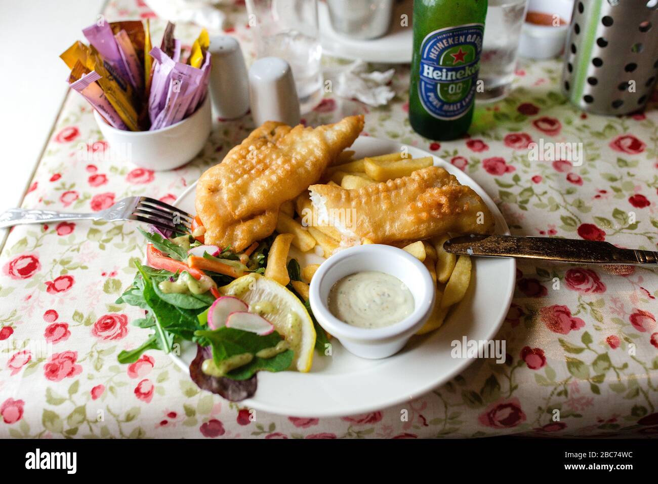 Plate of fish and chips served with lettuce, a slice of lemon and tartar sauce dip at the Campbell`s at the Reek pub in Westport, Ireland Stock Photo